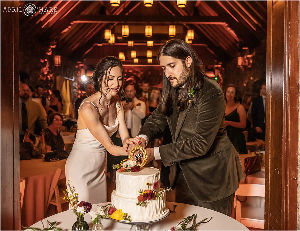 Bride and Groom cut their cake inside the Fireside Room at Boettcher Mansion in Colorado