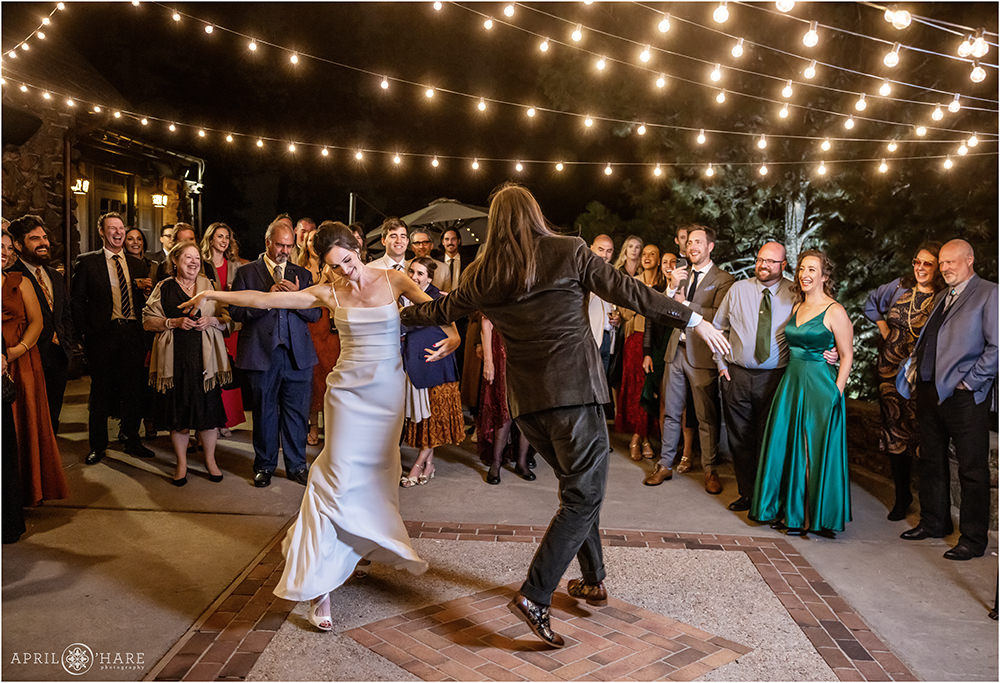 Cute photo of bride and groom having fun during their first dance under the string lights at Boettcher Mansion