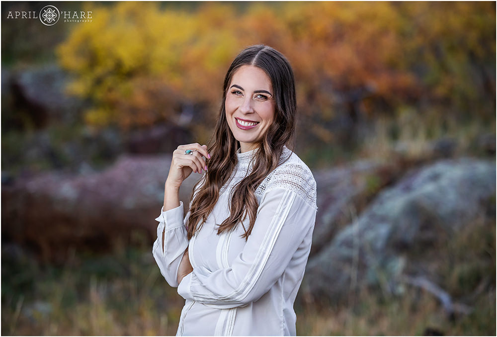 Woman with a pretty smile headshot Portrait with fall color backdrop in Boulder CO