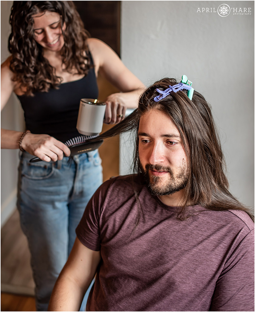 Groom gets his hair done on his wedding day at an airbnb in Golden CO