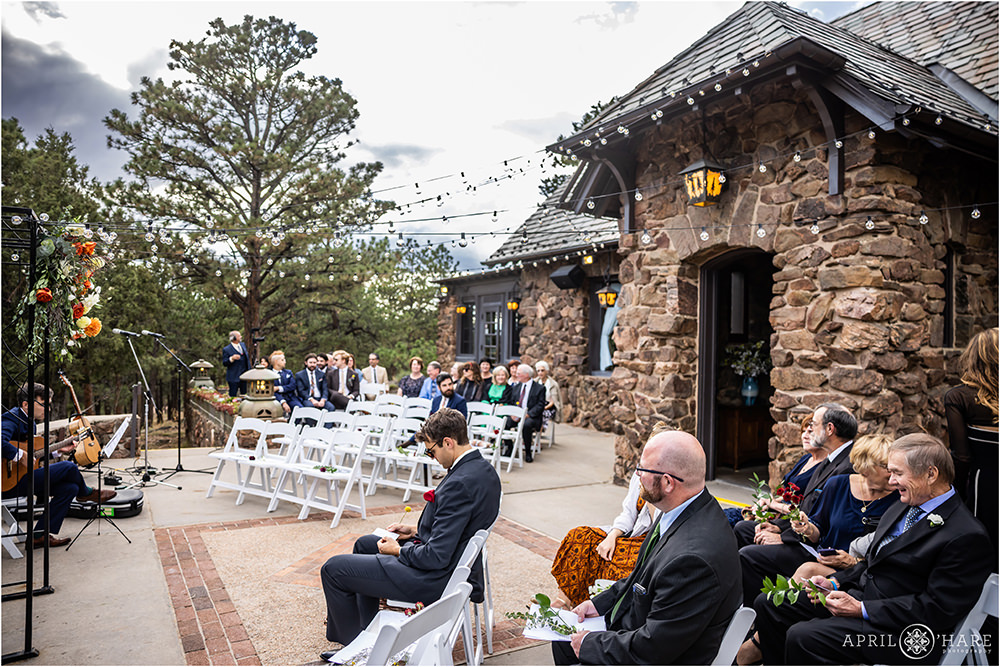 Wedding guests wait for the ceremony to begin on the outdoor patio outside of the Fireside Room at Boettcher Mansion in Colorado