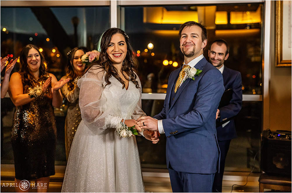 Bride and groom smile at their guests after getting married at their NYE wedding celebration inside of Coohills Restaurant in Denver CO