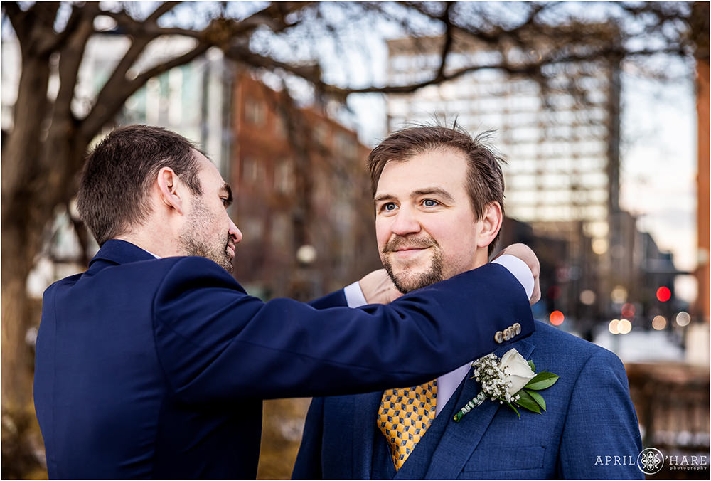 Groom gets some help with his tie on his winter wedding day in Denver CO