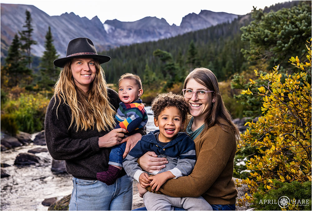 Adorable family of four with two sons and two moms are photographed at Long Lake in the Indian Peaks Wilderness area not far from Boulder CO