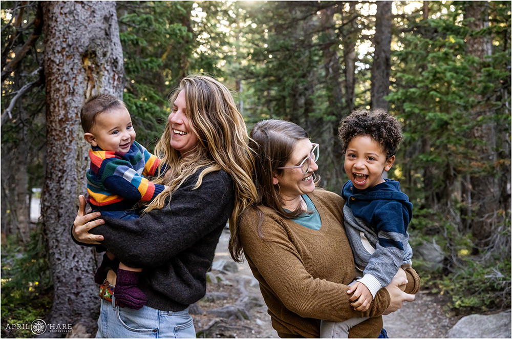 Two moms laugh with their sons in the forest at Indian Peaks Wilderness Area