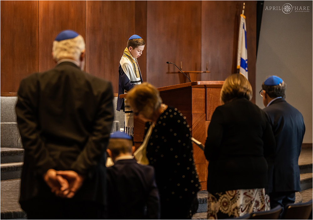 Bar mitzvah boy practices for his bar mitzvah service at Temple Sinai in Denver, CO