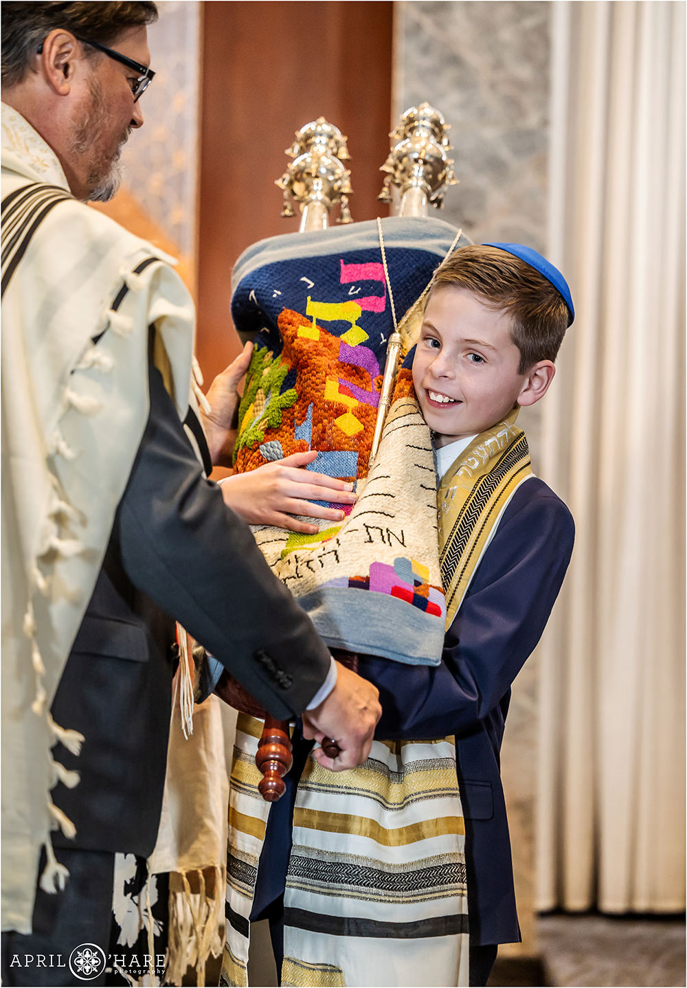Bar Mitzvah boy holds the Torah at his rehearsal at Temple Sinai in Denver