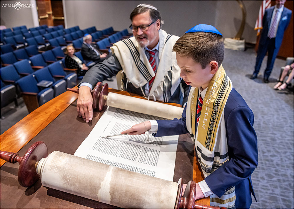 Bar mitzvah boy holds the yad as he reads from the Torah at his rehearsal at Temple Sinai in Denver, CO