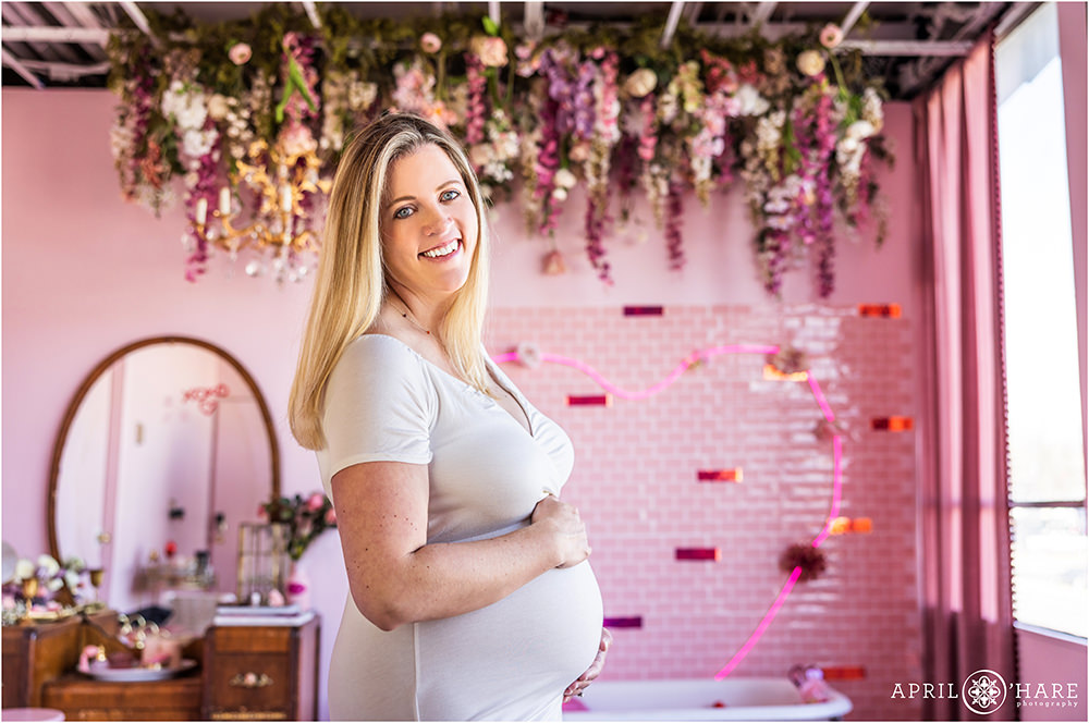 Pretty pink floral Valentine's Day maternity session for a woman expecting her first child at a Denver photography studio styled set.