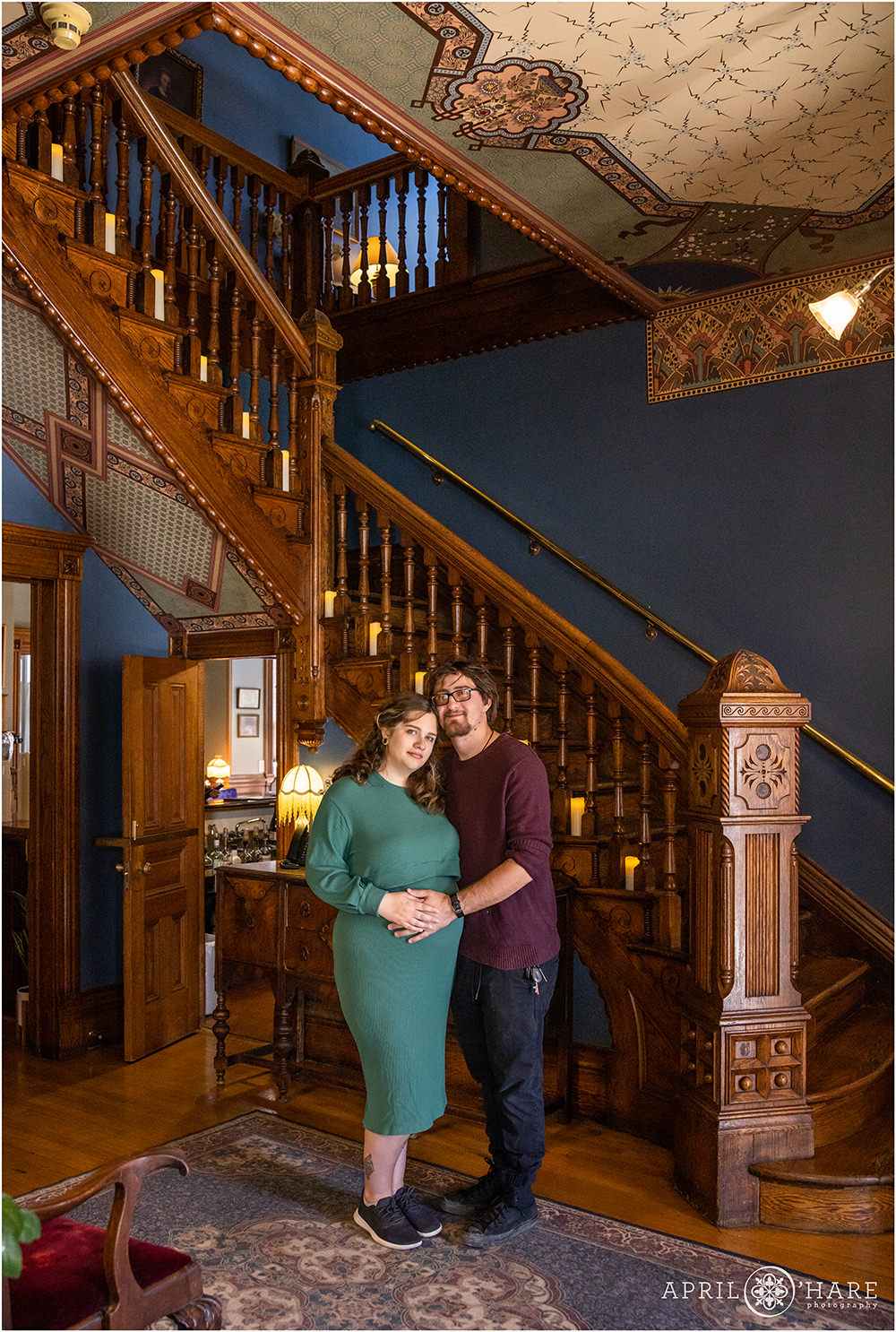 Couple expecting their first baby are photographed in the historic entry hallway at Lumber Baron Inn at their Denver Baby Shower