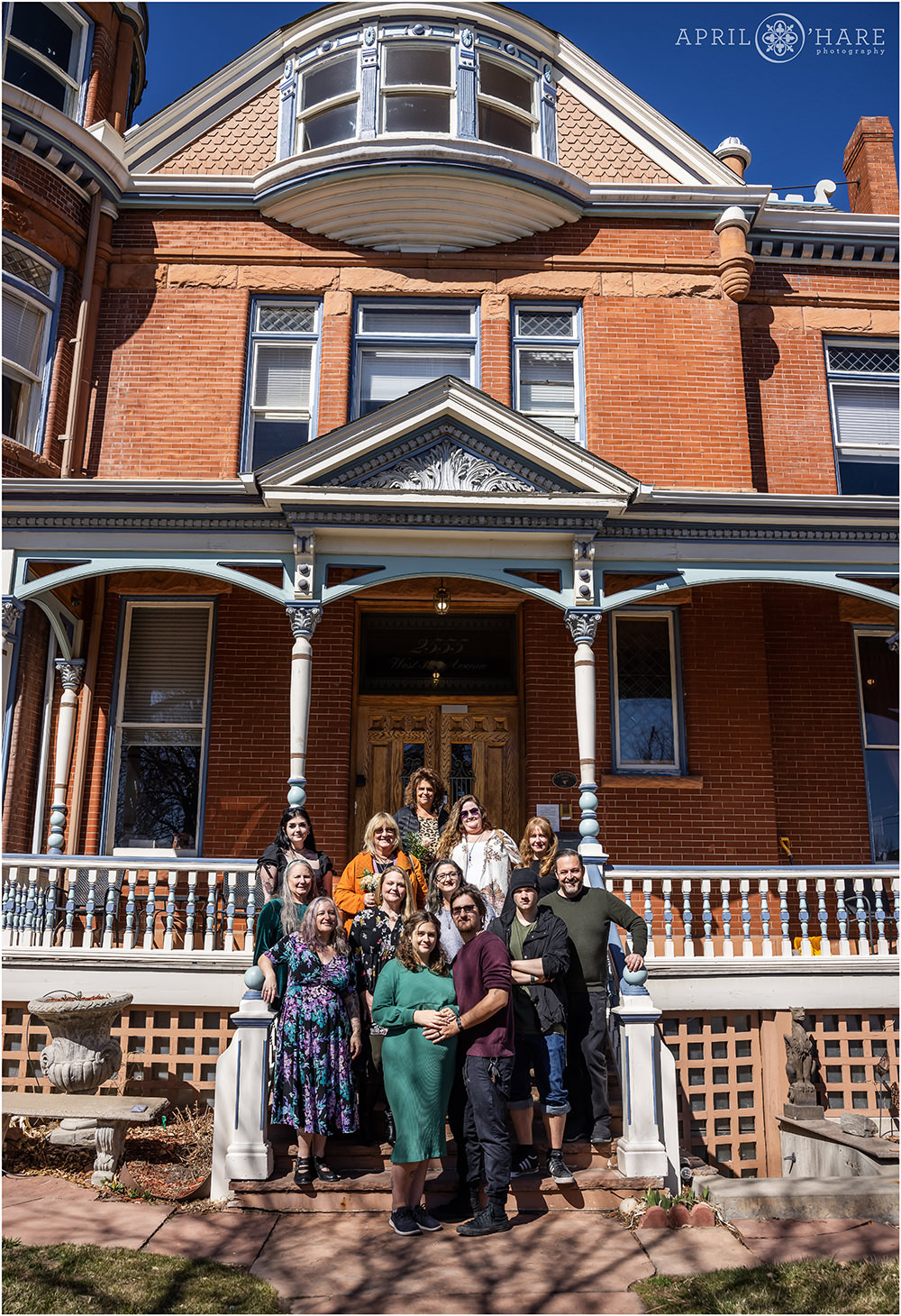 Family stand on the front stairs of the Lumber Baron Inn at a baby shower in Denver CO