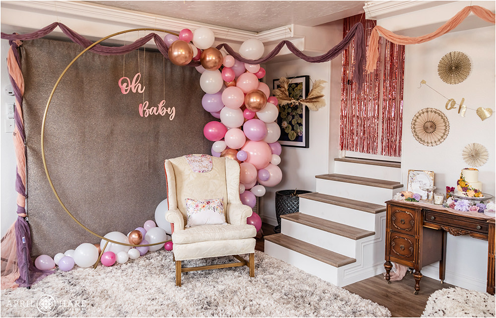 Cute white and pink chair set up in front of a pretty pink and purple balloon arch for a Denver Baby Shower