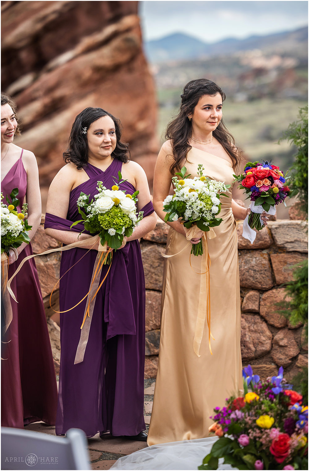 Maid of honor and bridesmaids stand during wedding ceremony at Red Rocks