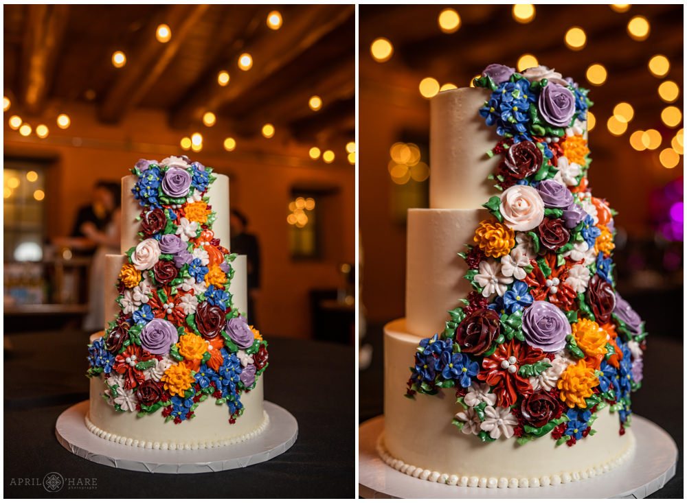 Pretty white three tiered wedding cake with colorful frosting flowers at Red Rocks Trading Post Backyard