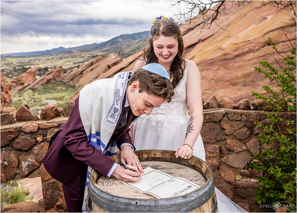 Bride and groom sign their marriage license after their ceremony at Red Rocks