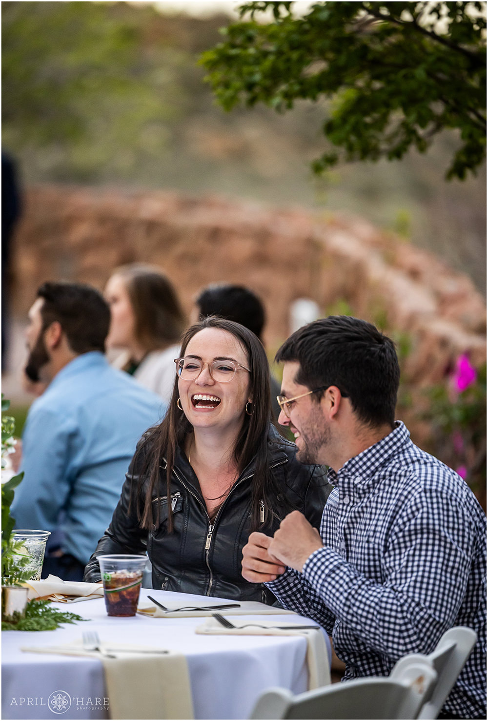 Guests laugh together during dinner at Red Rocks wedding reception in Colorado