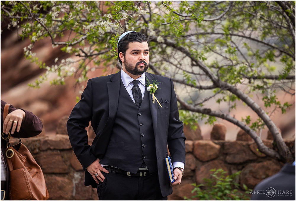 Officiant for a Jewish wedding waits for ceremony to start during spring at Red Rocks Trading Post