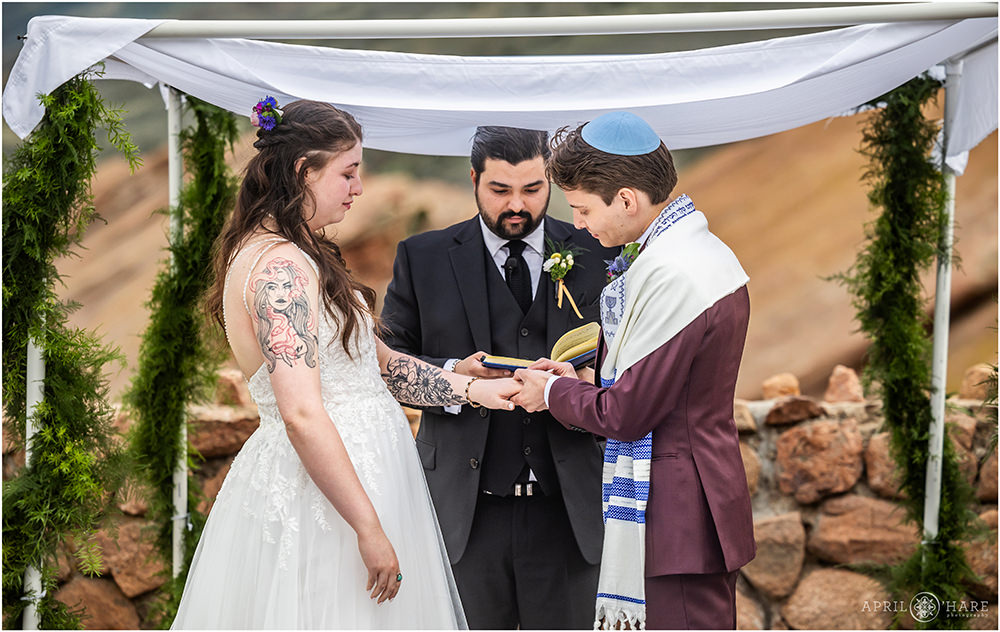 Bride and groom ring exchange during their ceremony at Red Rocks Trading Post