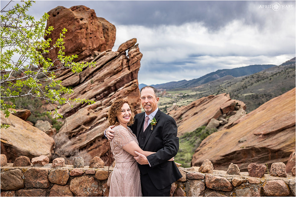 Parents of the bride get a portrait in front of the red rocks at Spring wedding in Morrison CO
