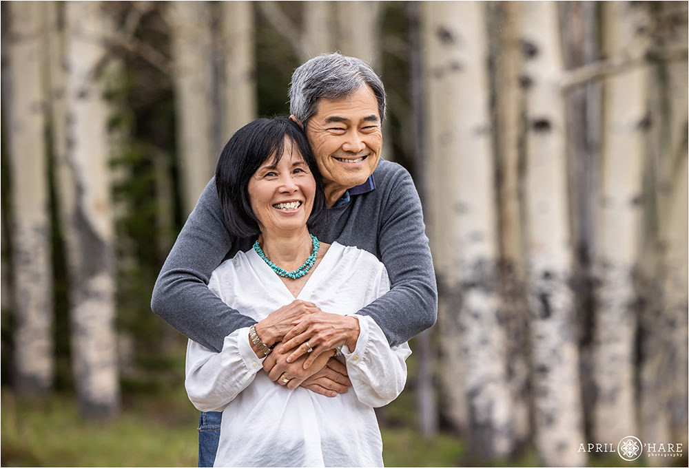 Sweet couples photo of a couple snuggling with aspen tree backdrop in Evergreen Colorado
