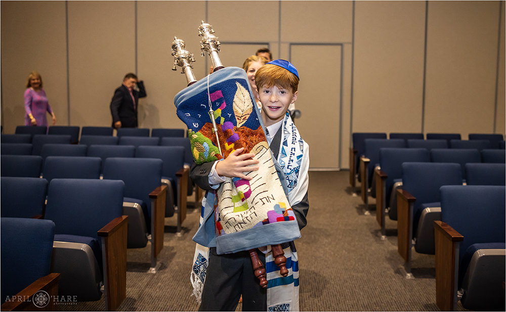 Boy carries the Torah at his bar mitzvah rehearsal in Denver at Temple Sinai