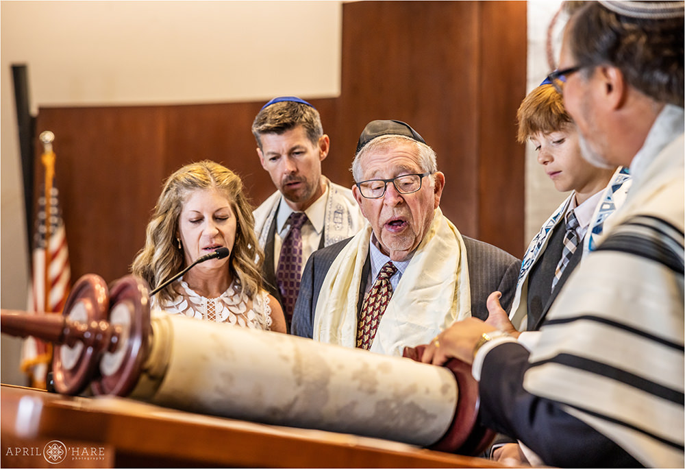 Grandfather reads from the Torah with his grandson on the day of his bar mitzvah at Temple Sinai in Denver