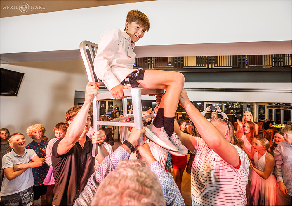 Bar mitzvah boy tossed in the air on a chair at his bar mitzvah party at Coors Field in Denver CO