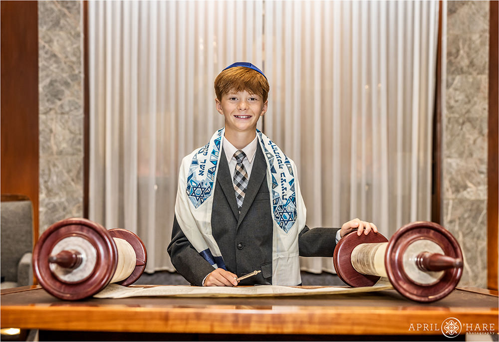 Portrait of a bar mitzvah boy with his hand on the torah at Temple Sinai in Denver CO