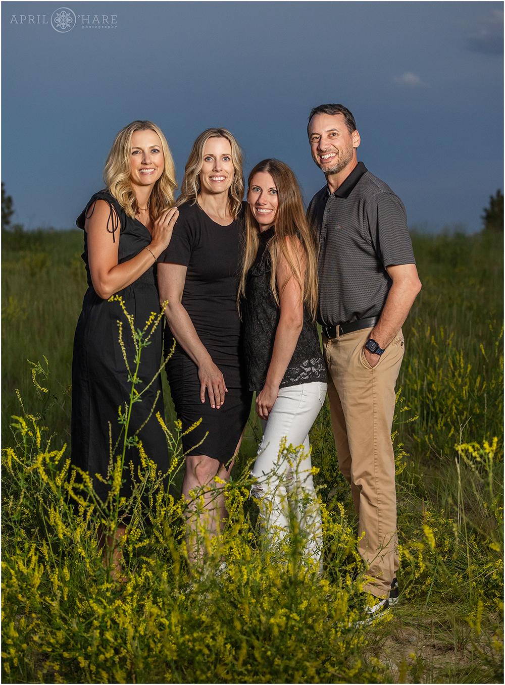Four adult siblings get a photo together at sunset in a field in Aurora Colorado