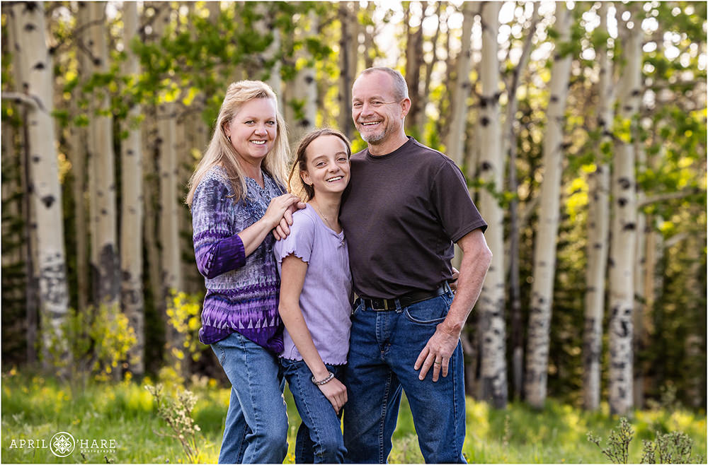 Family of three with aspen tree backdrop in Colorado