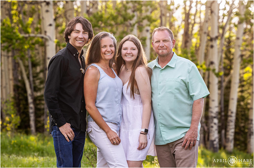 Family of four with aspen tree backdrop in Colorado
