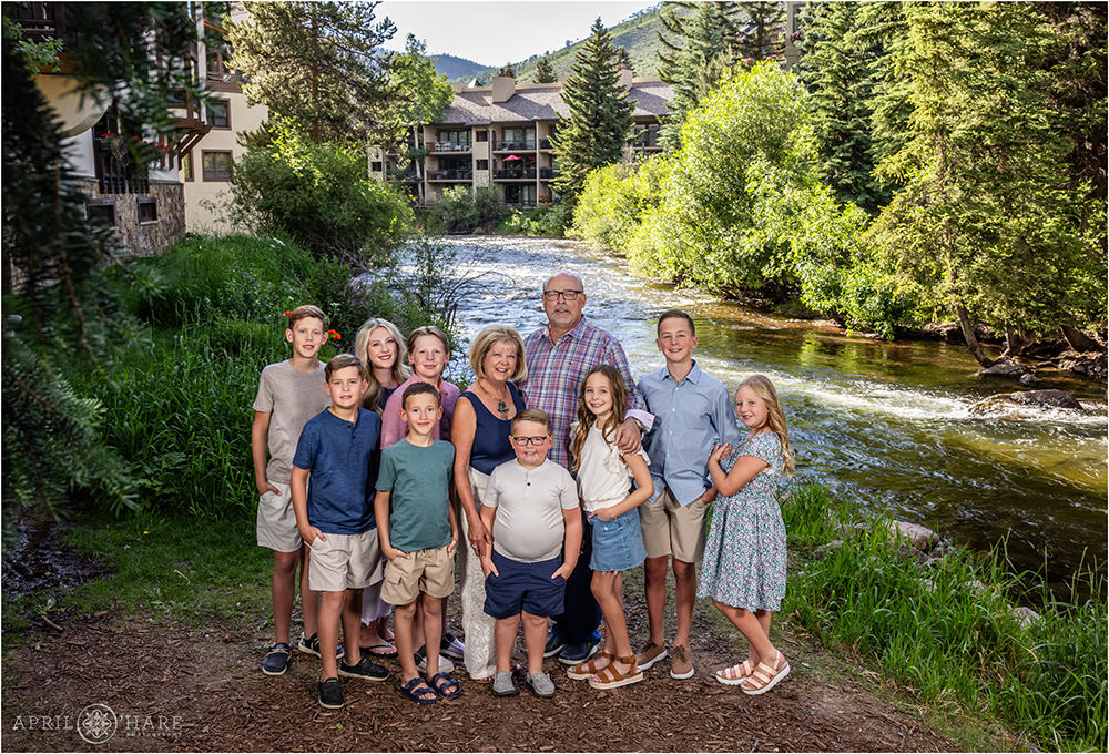 Summer photo of grandkids with their grandparents next to Gore Creek at Vail Village in Colorado