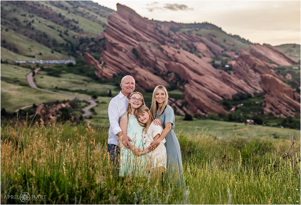 Beautiful family portrait at sunset with Red Rocks Amphitheater in the backdrop in Colorado