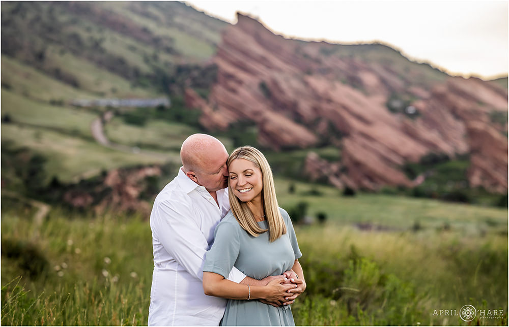 Sweet romantic couples photo with Red Rocks Amphitheater in the backdrop at a family photography shoot in Colorado