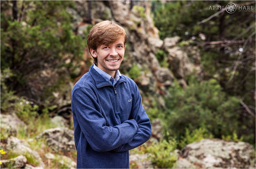 Senior photo in the woods with a rock backdrop at Knoll Willows Open Space in Estes Park Colorado