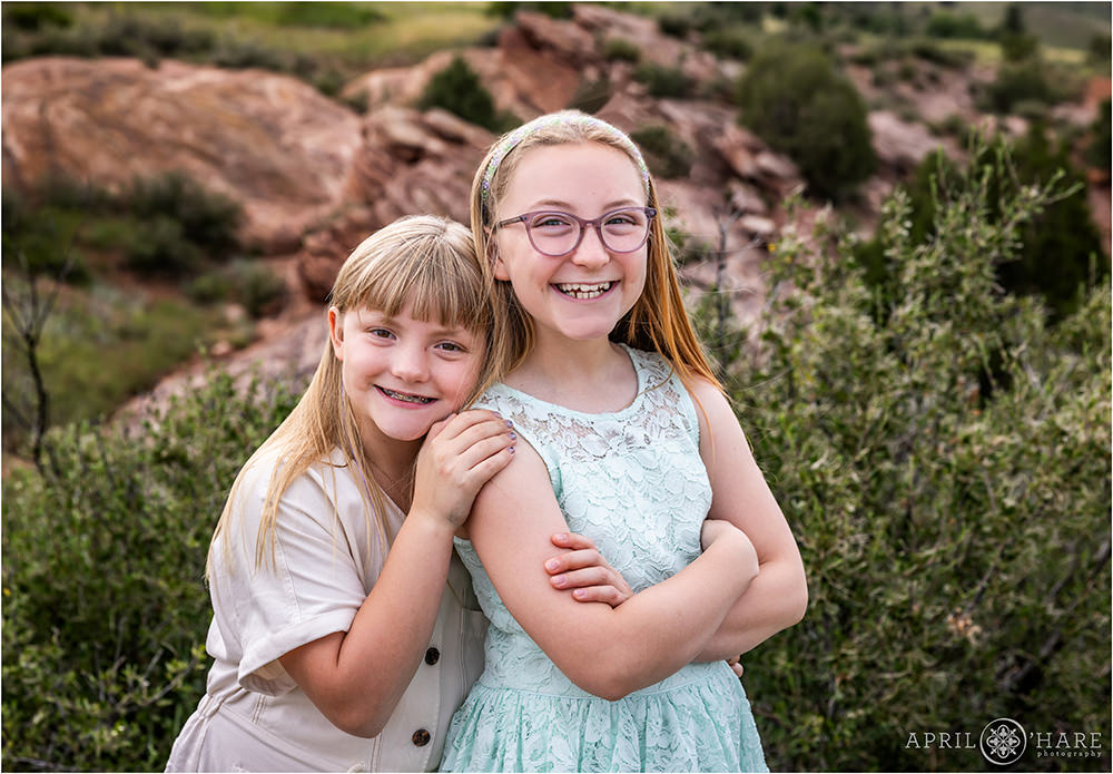 Cute photo of two sisters posing for a photo in the pretty red rock scenery at Morrison Trailhead