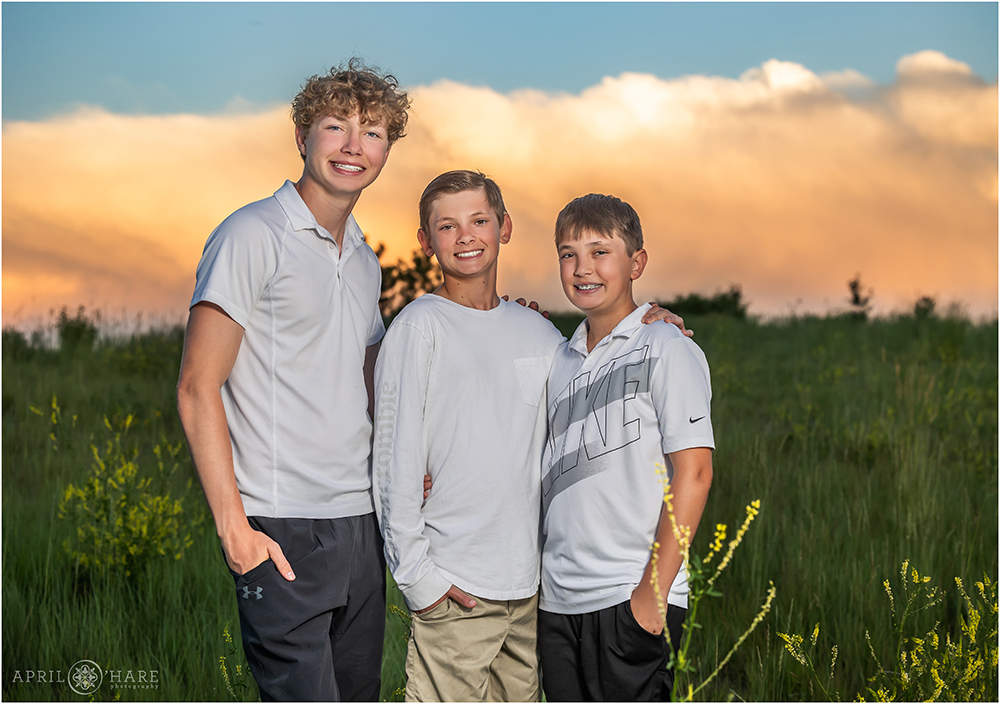Three teen brothers pose for a photo together at sunset at their home in Aurora, CO