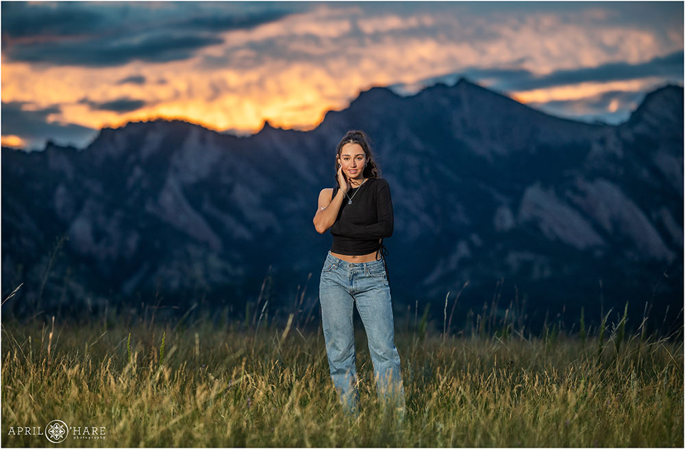 Pretty Dramatic Sunset Photo at Flatirons Vista Trailhead for a senior photo for a girl wearing a black top with jeans in Boulder CO