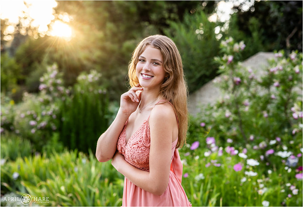 Senior girl wearing a soft pink crocheted lace dress with backlight at Denver Botanic Gardens senior photo session