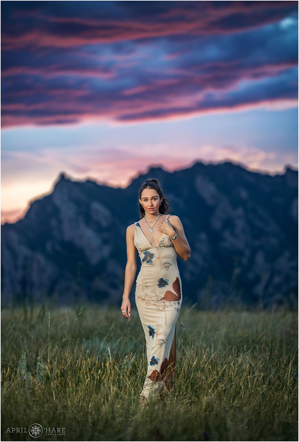 Beautiful sunset mountain backdrop for a senior portrait at the Flatirons Vista Trail in Boulder CO