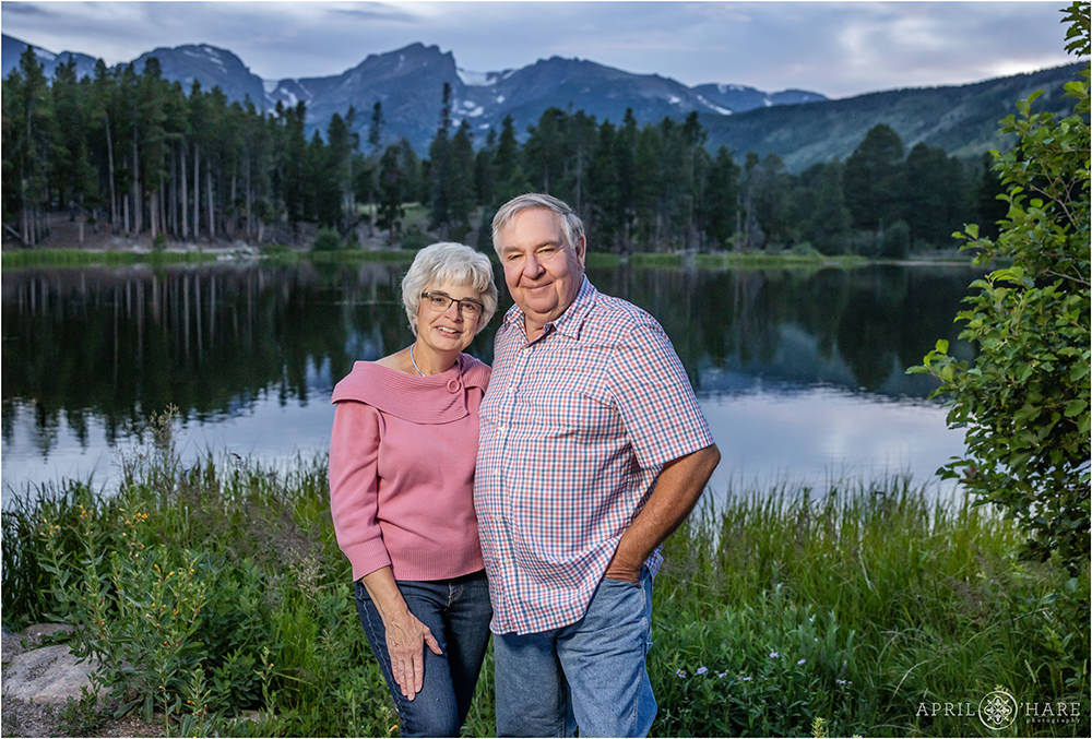 Grandparents couples photo with mountain backdrop at Sprague Lake during summer at RMNP