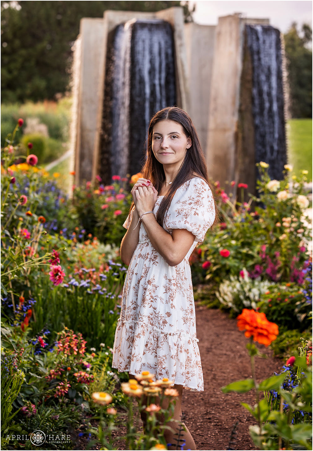 Pretty Colorful Garden Senior Portraits with large waterfall sculpture backdrop at Denver Botanic Gardens