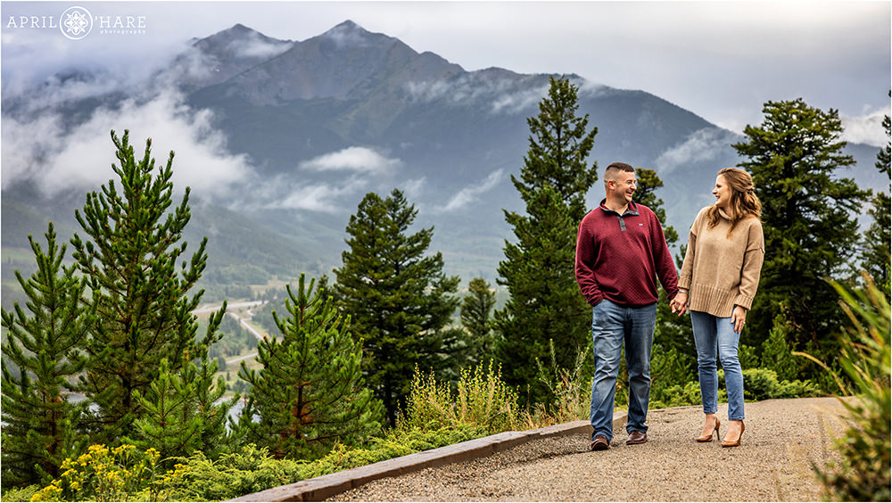 Couple walk along the path at Sapphire Point on a stormy summer evening with a misty mountain backdrop