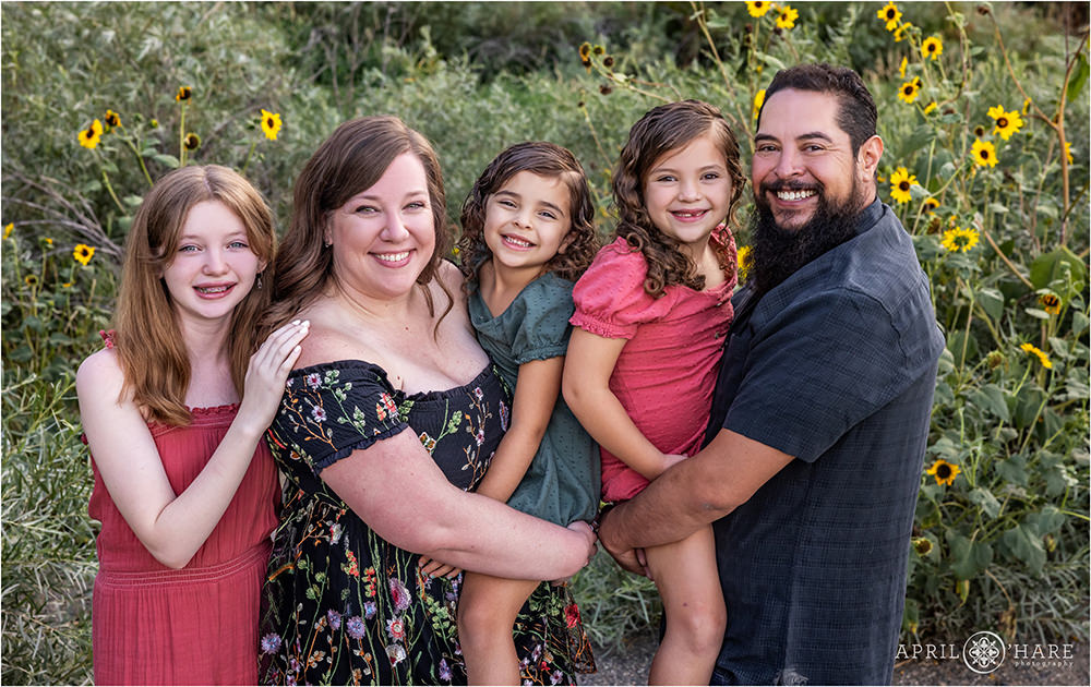 Family of 5 poses for a photo together in front of the wild sunflowers in Denver CO