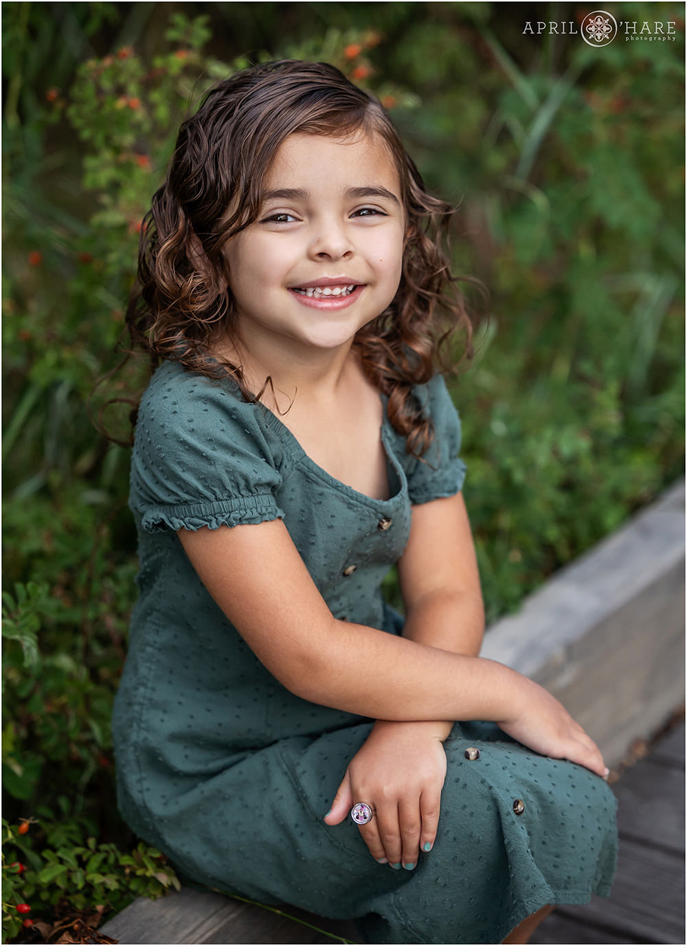 Cute little girl wearing a green dress at her family session at James A Bible Park in Denver Colorado