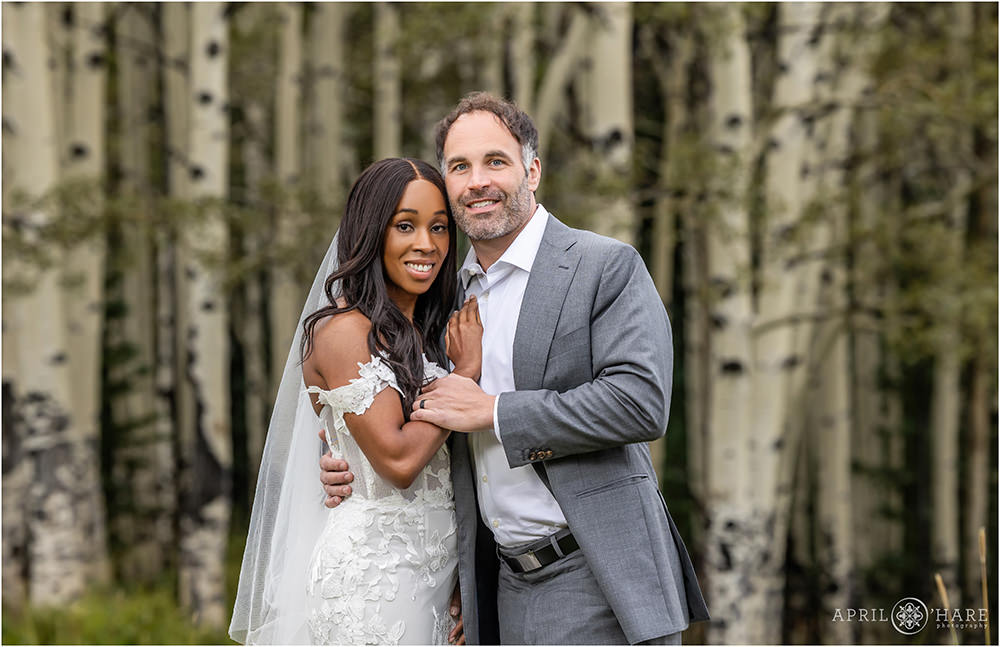 Aspen tree backdrop for a couple in their wedding attire in the woods of Evergreen Colorado