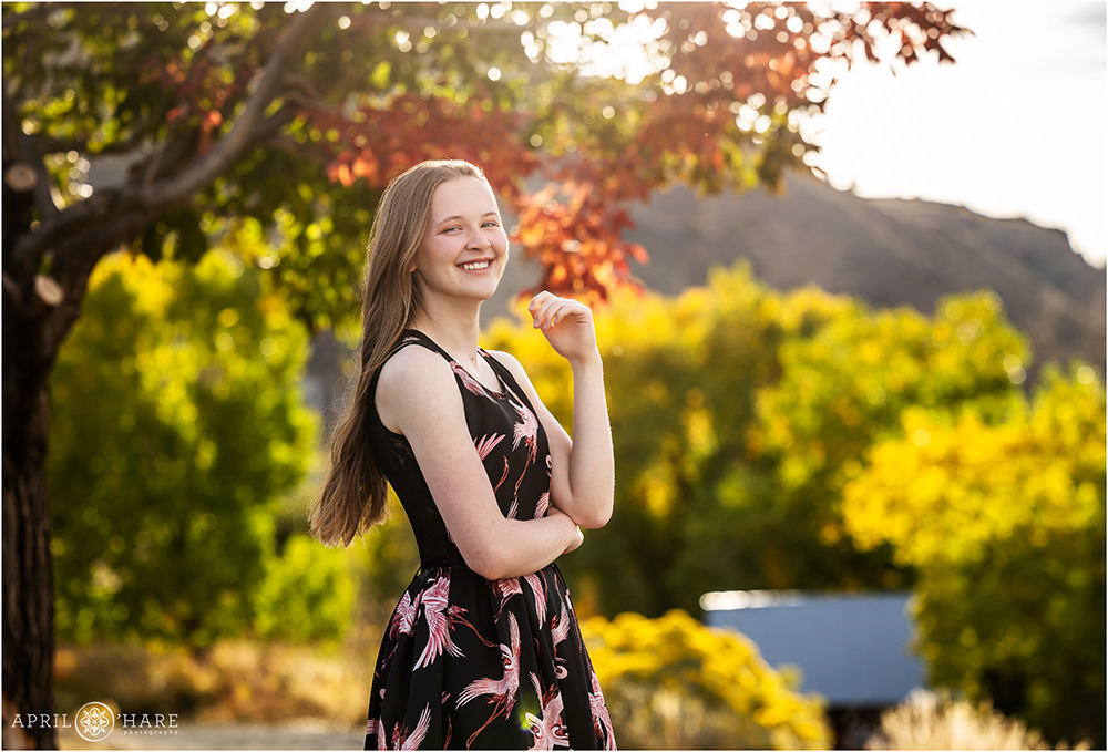 Cute senior girl poses for her yearbook photos in the fall color at Clear Creek History Park in Golden Colorado