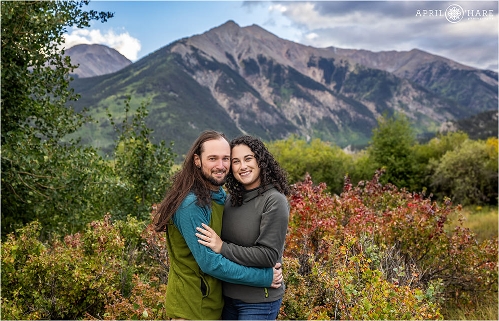 Adorable classic engagement photo of a couple with a beautful mountain backdrop and fall color at Twin Lakes Historic District in Colorado