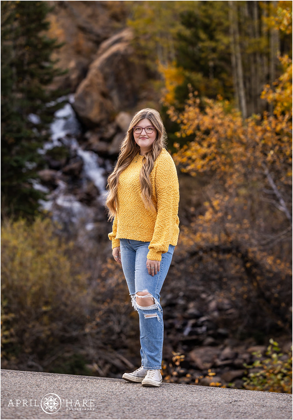 Stunning waterfall backdrop with golden fall color for a senior portrait on Guanella Pass in Colorado