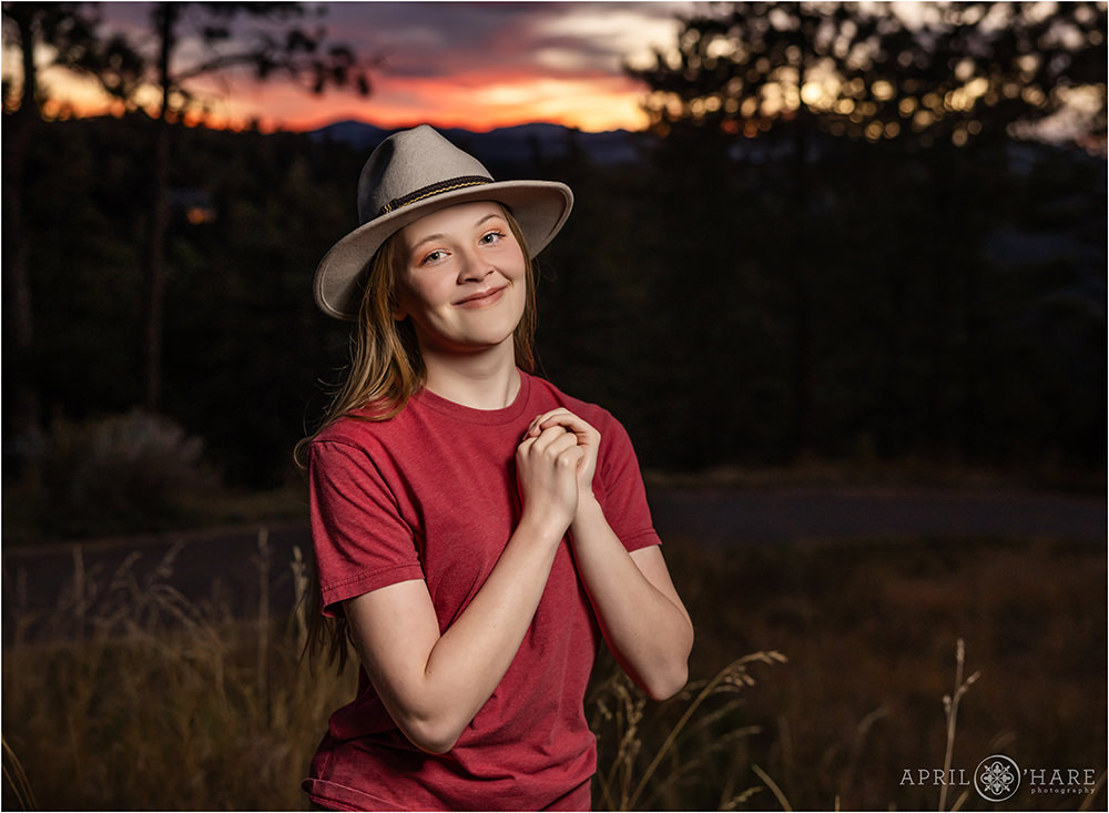 Cute senior girl wearing a hat at sunset on Lookout Mountain in Golden Colorado
